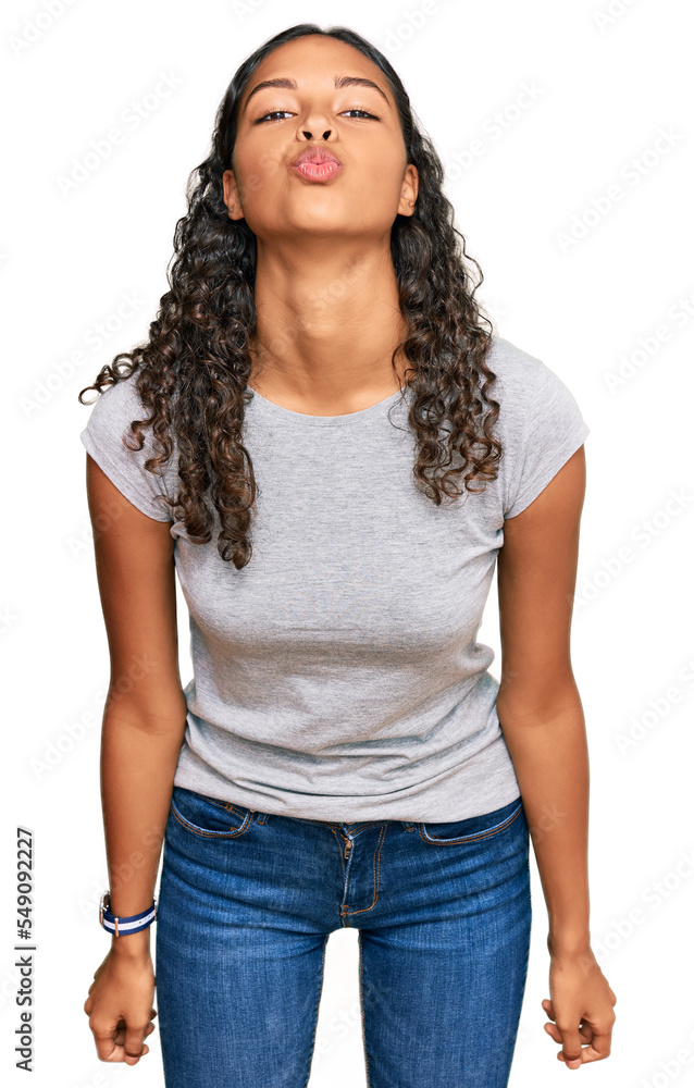 Fototapeta premium Young african american girl wearing casual clothes looking at the camera blowing a kiss on air being lovely and sexy. love expression.