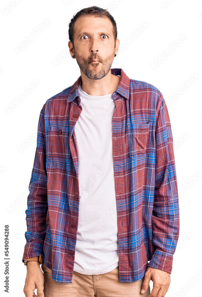 Young handsome man wearing casual clothes making fish face with lips, crazy and comical gesture. funny expression. Young handsome man wearing casual clothes making fish face with lips, crazy and comical gesture. funny expression.