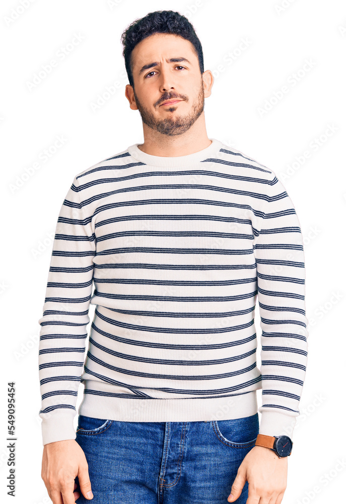 Young hispanic man wearing casual clothes relaxed with serious expression on face. simple and natural looking at the camera. Young hispanic man wearing casual clothes relaxed with serious expression on face. simple and natural looking at the camera.