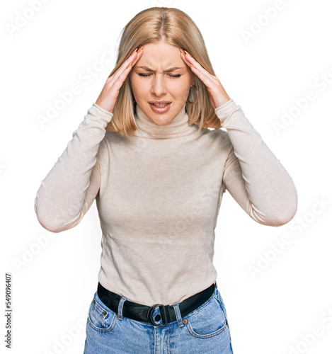 Young blonde woman wearing casual clothes with hand on head for pain in head because stress. suffering migraine.