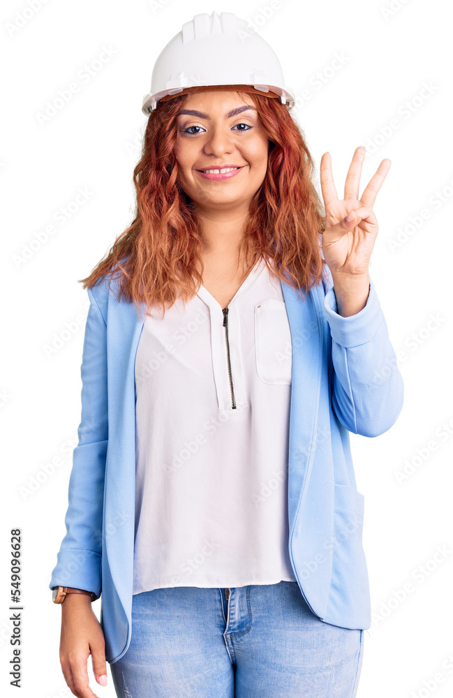 Young latin woman wearing architect hardhat showing and pointing up with fingers number three while smiling confident and happy. Young latin woman wearing architect hardhat showing and pointing up with fingers number three while smiling confident and happy.