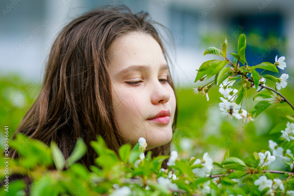 Portrait of a beautiful teenage girl among cherry blossoms in spring Portrait of a beautiful teenage girl among cherry blossoms in spring