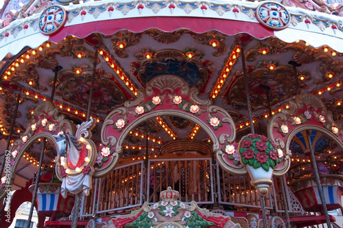 Illuminated bright beautiful carousel with toys and flowers at the festive winter fair