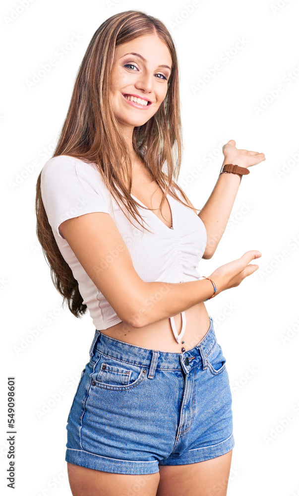 Young beautiful blonde woman wearing casual white tshirt inviting to enter smiling natural with open hand Young beautiful blonde woman wearing casual white tshirt inviting to enter smiling natural with open hand