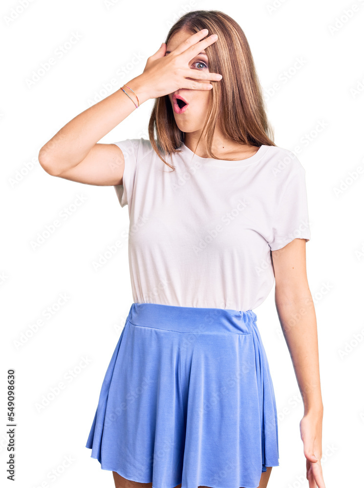 Young beautiful blonde woman wearing summer style peeking in shock covering face and eyes with hand, looking through fingers with embarrassed expression. Young beautiful blonde woman wearing summer style peeking in shock covering face and eyes with hand, looking through fingers with embarrassed expression.
