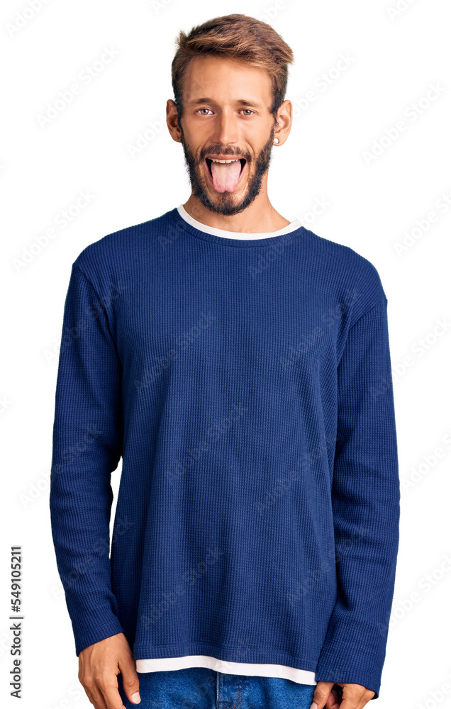 Handsome blond man with beard wearing casual sweater sticking tongue out happy with funny expression. emotion concept. Handsome blond man with beard wearing casual sweater sticking tongue out happy with funny expression. emotion concept.