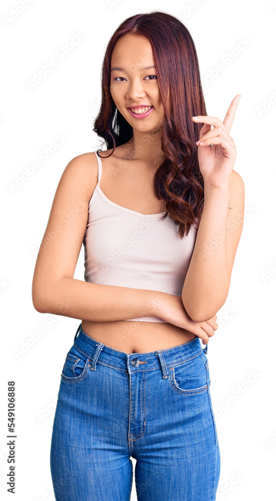 Young beautiful chinese girl wearing casual clothes with a big smile on face, pointing with hand and finger to the side looking at the camera. Young beautiful chinese girl wearing casual clothes with a big smile on face, pointing with hand and finger to the side looking at the camera.