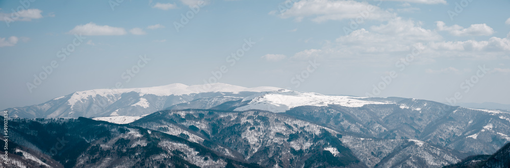 Large panorama of stunning snow-capped mountains with blue hue