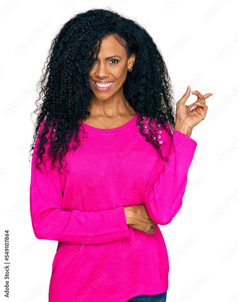 Middle age african american woman wearing casual clothes with a big smile on face, pointing with hand and finger to the side looking at the camera. Middle age african american woman wearing casual clothes with a big smile on face, pointing with hand and finger to the side looking at the camera.