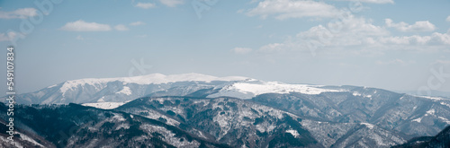 Large panorama of stunning snow-capped mountains with blue hue