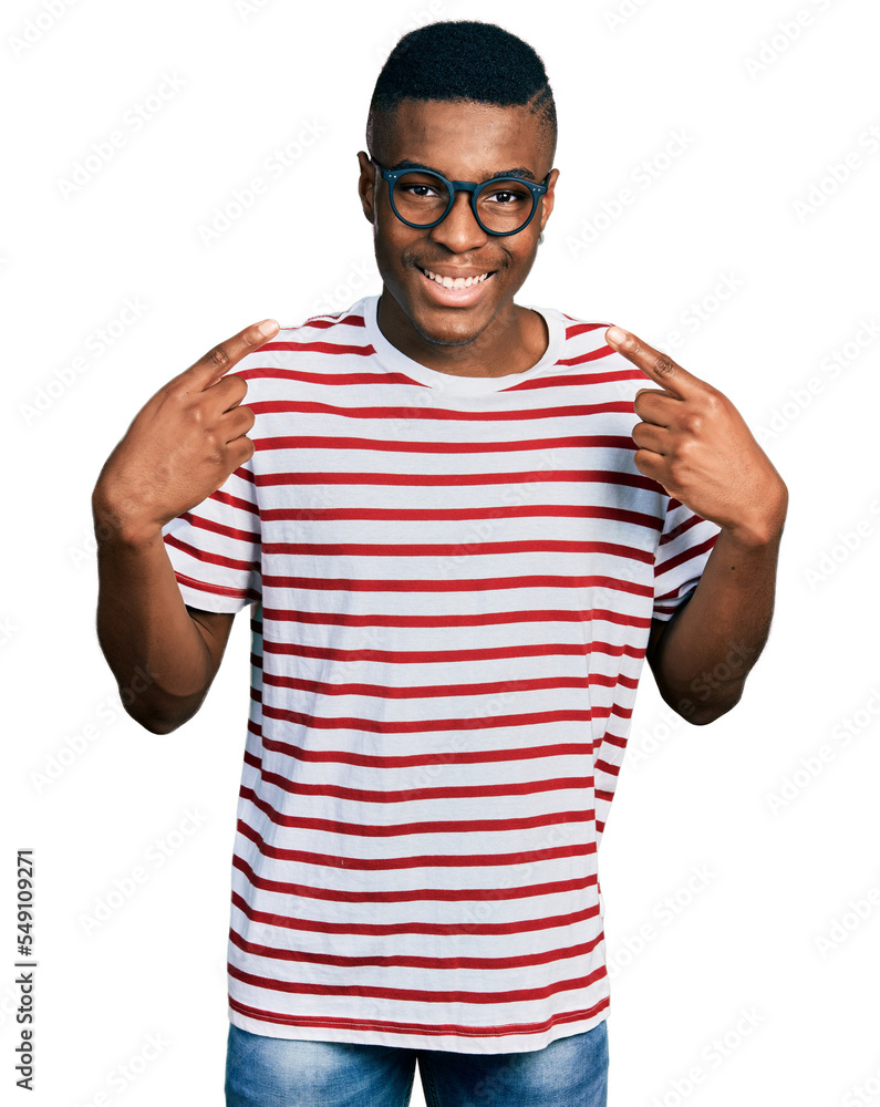 Young african american man wearing casual t shirt and glasses smiling cheerful showing and pointing with fingers teeth and mouth. dental health concept. Young african american man wearing casual t shirt and glasses smiling cheerful showing and pointing with fingers teeth and mouth. dental health concept.