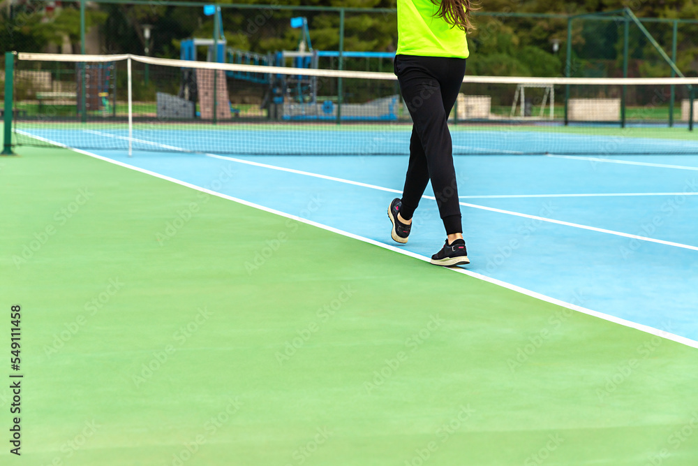 Legs of the young girl on tennis court. Walking the tennis court. Sport life.
