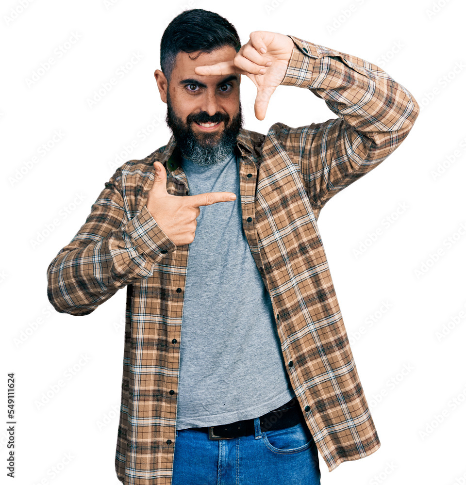 Hispanic man with beard wearing casual shirt smiling making frame with hands and fingers with happy face. creativity and photography concept. Hispanic man with beard wearing casual shirt smiling making frame with hands and fingers with happy face. creativity and photography concept.
