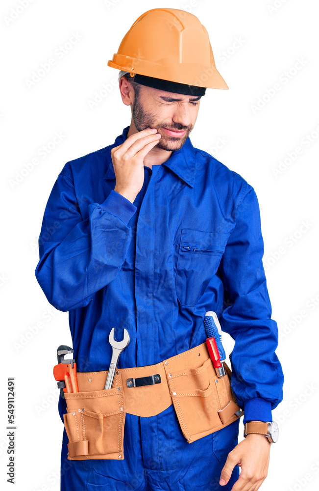 Young hispanic man wearing worker uniform touching mouth with hand with painful expression because of toothache or dental illness on teeth. dentist Young hispanic man wearing worker uniform touching mouth with hand with painful expression because of toothache or dental illness on teeth. dentist