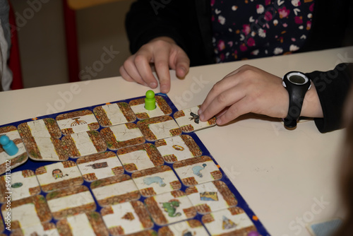 mains d'une enfant jouant à des jeux de société avec des pions de couleur photo