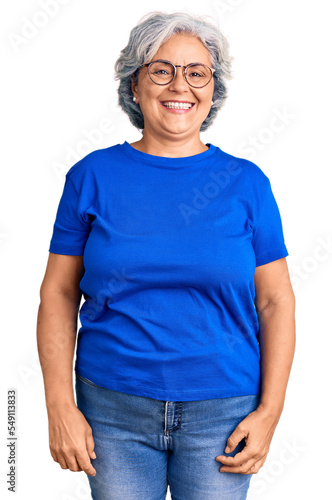 Senior woman with gray hair wearing casual clothes and glasses looking positive and happy standing and smiling with a confident smile showing teeth