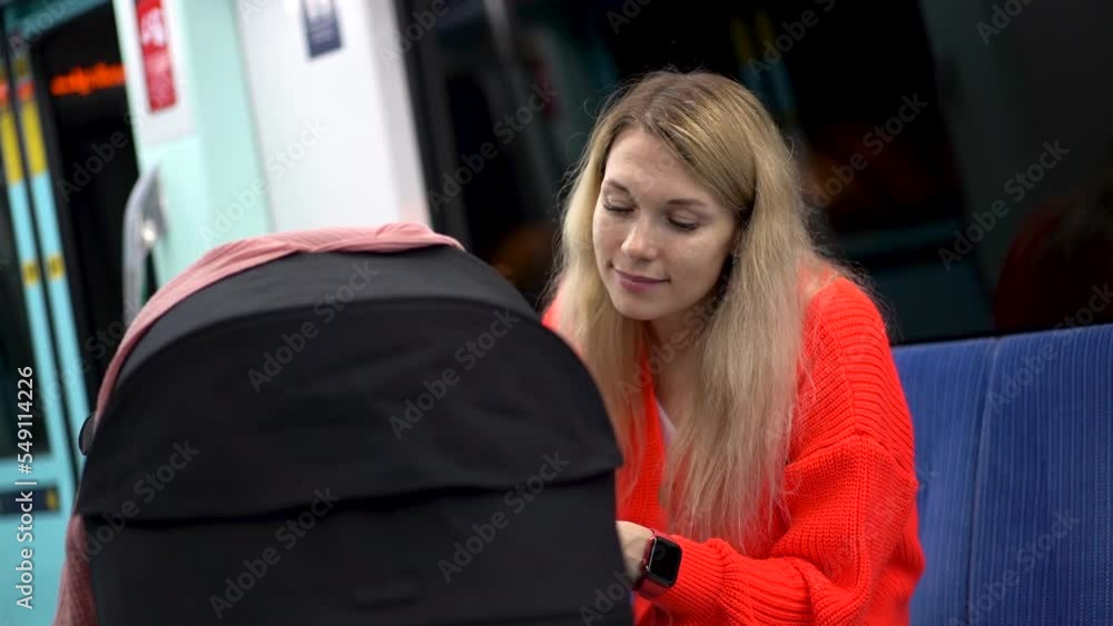Woman smiling at her child while sitting in a subway car Woman smiling at her child while sitting in a subway car