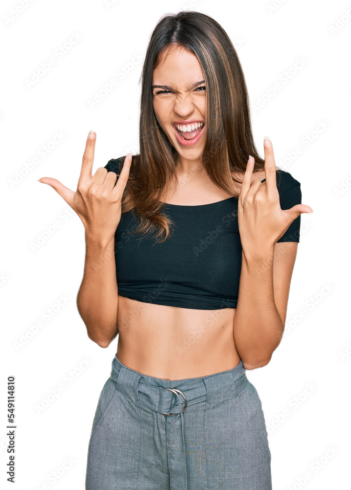 Young brunette woman wearing casual clothes shouting with crazy expression doing rock symbol with hands up. music star. heavy concept. Young brunette woman wearing casual clothes shouting with crazy expression doing rock symbol with hands up. music star. heavy concept.