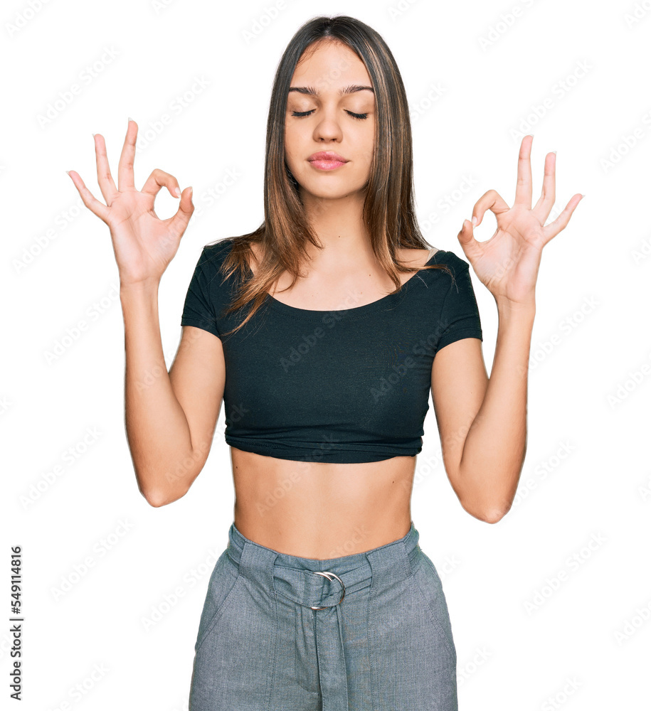 Young brunette woman wearing casual clothes relax and smiling with eyes closed doing meditation gesture with fingers. yoga concept. Young brunette woman wearing casual clothes relax and smiling with eyes closed doing meditation gesture with fingers. yoga concept.