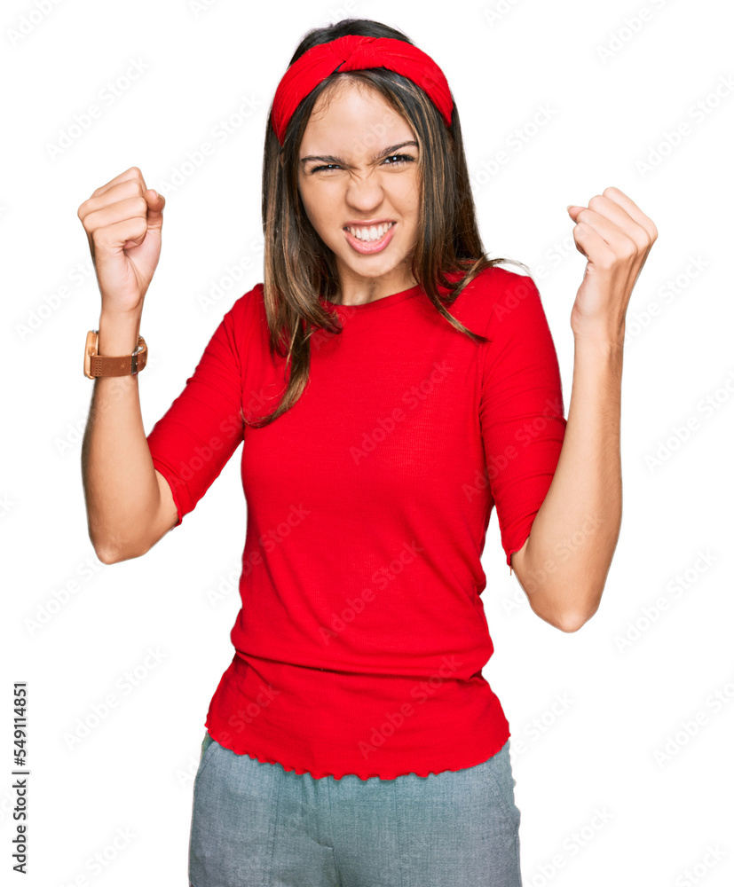 Young brunette woman wearing casual clothes angry and mad raising fists frustrated and furious while shouting with anger. rage and aggressive concept. Young brunette woman wearing casual clothes angry and mad raising fists frustrated and furious while shouting with anger. rage and aggressive concept.