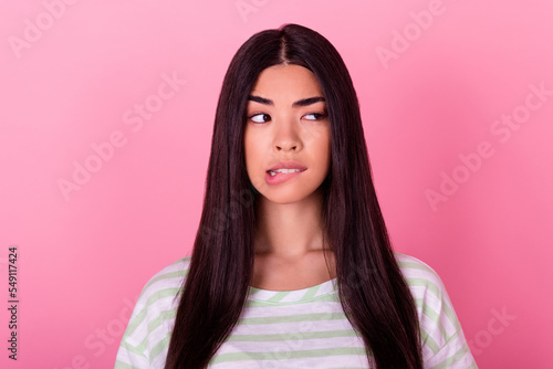 Portrait of interested lady look empty space bite teeth lips try guess what is going on isolated pastel color background