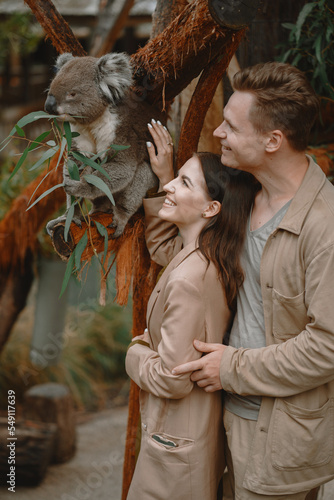 Photography Couple in the reserve is playing with a koala