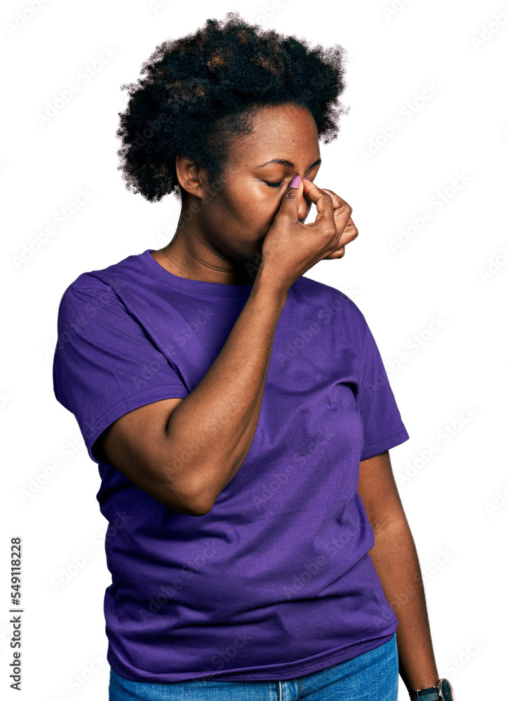 African american woman with afro hair wearing casual purple t shirt tired rubbing nose and eyes feeling fatigue and headache. stress and frustration concept. African american woman with afro hair wearing casual purple t shirt tired rubbing nose and eyes feeling fatigue and headache. stress and frustration concept.