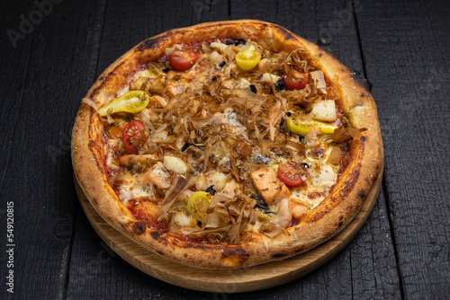 tasty pizza with cheese and vegetables on a wooden dark table 