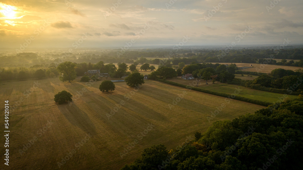 Obraz premium Aerial view of foggy field after rain in sun beams, West Susex, UK