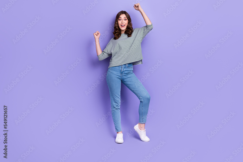 Full length photo of overjoyed cool lady raise hand arm glad buy tickets concert favorite singer isolated on purple color background Full length photo of overjoyed cool lady raise hand arm glad buy tickets concert favorite singer isolated on purple color background