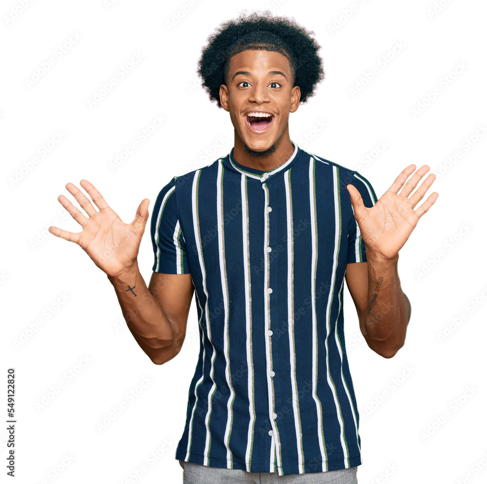African american man with afro hair wearing casual clothes celebrating crazy and amazed for success with arms raised and open eyes screaming excited. winner concept African american man with afro hair wearing casual clothes celebrating crazy and amazed for success with arms raised and open eyes screaming excited. winner concept