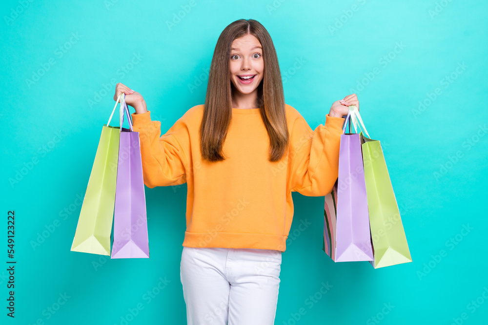 Photo of young excited impressed teen girl hold packages black friday proposition open new brand shop isolated on cyan color background Photo of young excited impressed teen girl hold packages black friday proposition open new brand shop isolated on cyan color background
