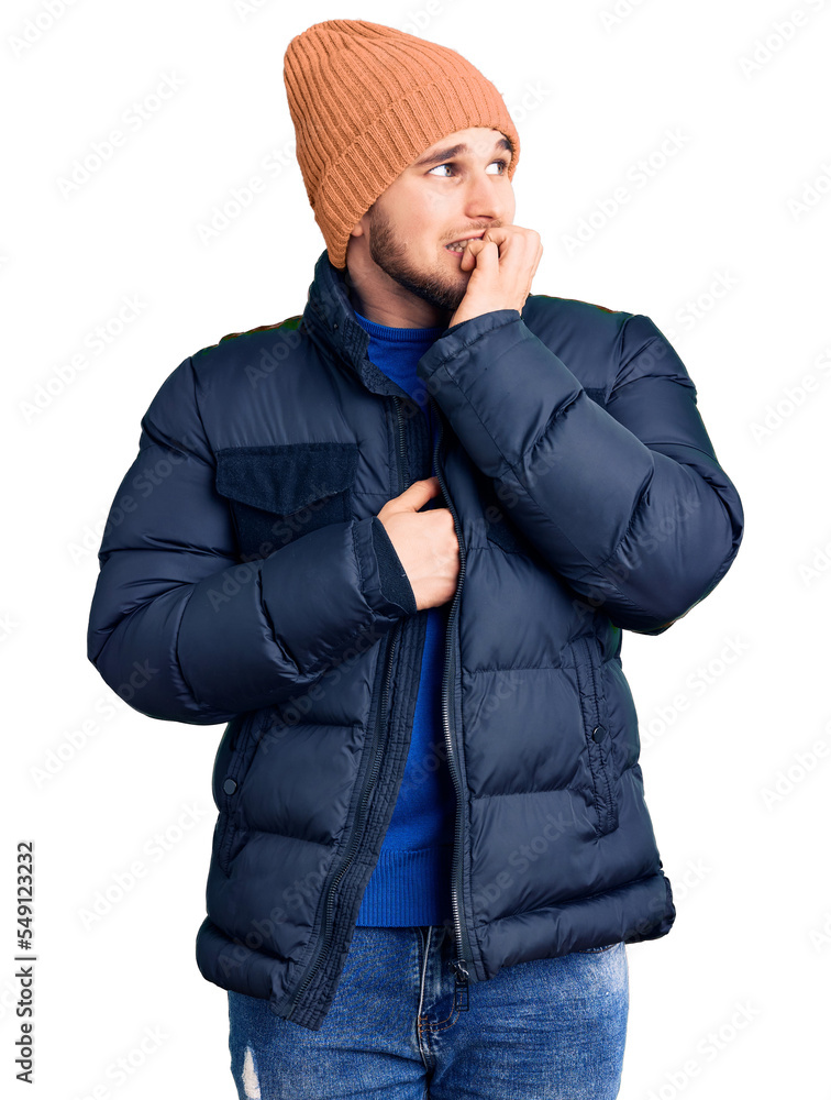 Young handsome man wearing winter clothes looking stressed and nervous with hands on mouth biting nails. anxiety problem. Young handsome man wearing winter clothes looking stressed and nervous with hands on mouth biting nails. anxiety problem.