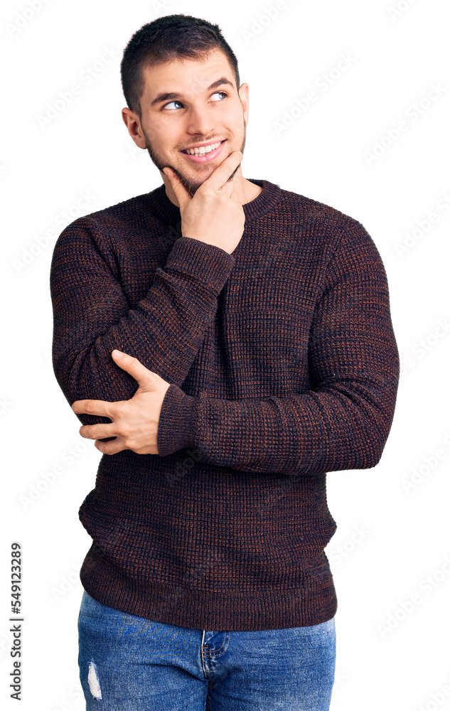 Young handsome man wearing casual sweater with hand on chin thinking about question, pensive expression. smiling with thoughtful face. doubt concept. Young handsome man wearing casual sweater with hand on chin thinking about question, pensive expression. smiling with thoughtful face. doubt concept.