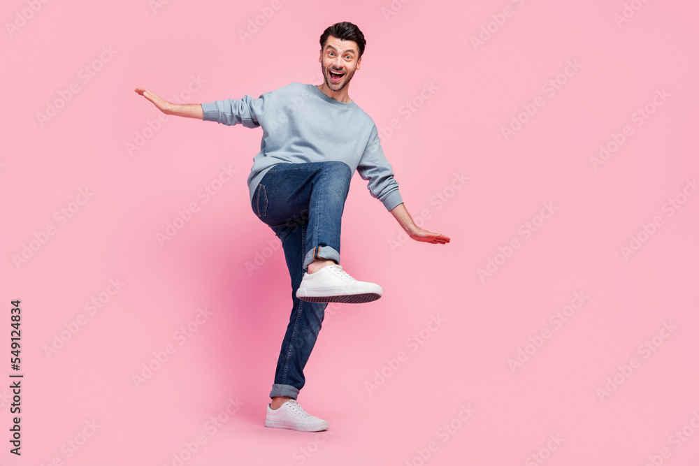 Full size photo of young funny grimace excited guy student wear grey jumper jeans crazy dance celebrate salary holidays isolated on pink color background