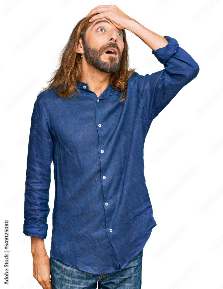 Attractive man with long hair and beard wearing casual clothes surprised with hand on head for mistake, remember error. forgot, bad memory concept. Attractive man with long hair and beard wearing casual clothes surprised with hand on head for mistake, remember error. forgot, bad memory concept.