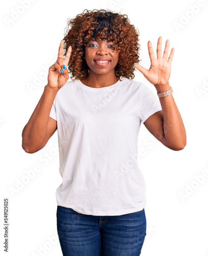 Young african american woman wearing casual white tshirt showing and pointing up with fingers number seven while smiling confident and happy.
