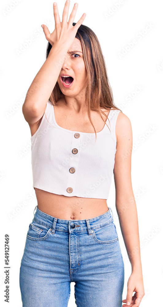 Young beautiful girl wearing casual sleeveless t shirt surprised with hand on head for mistake, remember error. forgot, bad memory concept. Young beautiful girl wearing casual sleeveless t shirt surprised with hand on head for mistake, remember error. forgot, bad memory concept.
