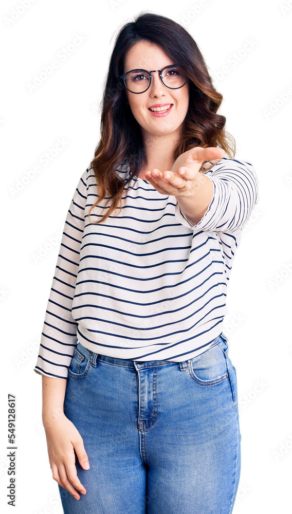 Beautiful young brunette woman wearing casual clothes and glasses smiling friendly offering handshake as greeting and welcoming. successful business. Beautiful young brunette woman wearing casual clothes and glasses smiling friendly offering handshake as greeting and welcoming. successful business.