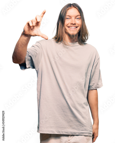 Wallpaper Mural Handsome caucasian man with long hair wearing casual clothes smiling and confident gesturing with hand doing small size sign with fingers looking and the camera. measure concept. Torontodigital.ca