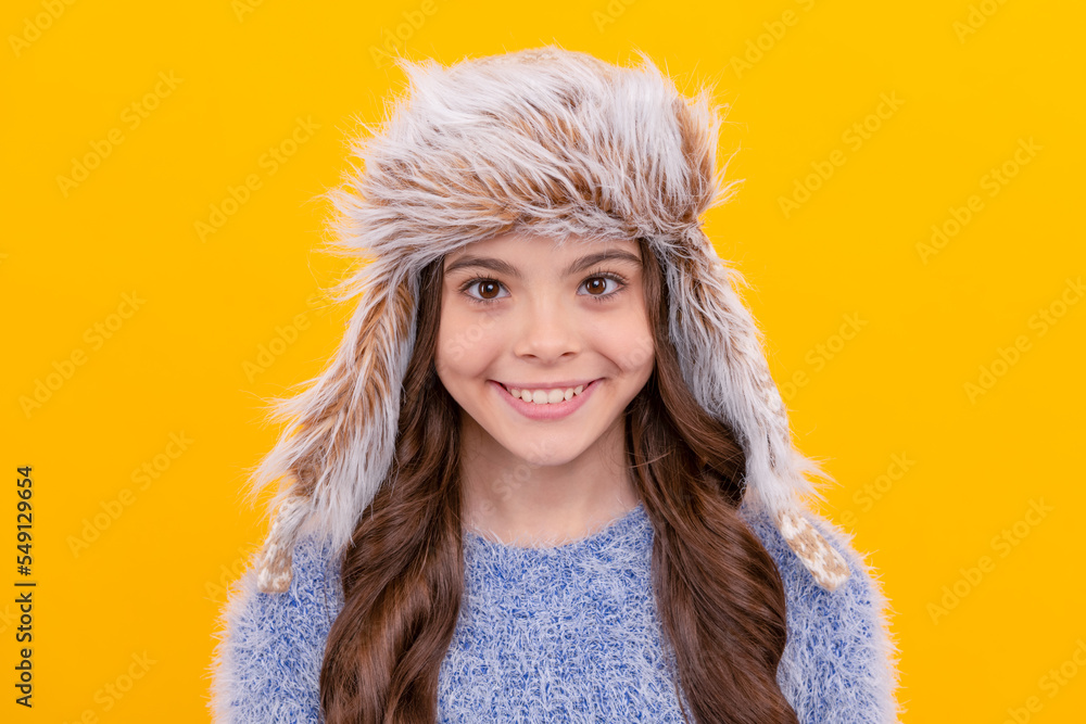 happy teen girl wear earflap hat on yellow background, winter clothing