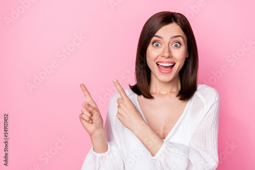 Photo portrait of nice young woman suggest advert space unbelievable sales dressed stylish white look isolated on pink color background © deagreez