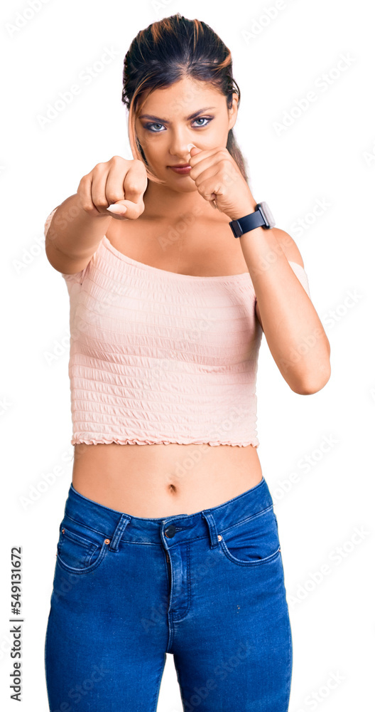 Young beautiful woman wearing casual clothes punching fist to fight, aggressive and angry attack, threat and violence Young beautiful woman wearing casual clothes punching fist to fight, aggressive and angry attack, threat and violence