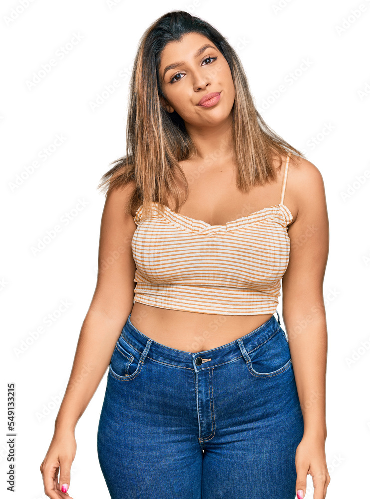 Beautiful brunette woman wearing casual clothes relaxed with serious expression on face. simple and natural looking at the camera. Beautiful brunette woman wearing casual clothes relaxed with serious expression on face. simple and natural looking at the camera.