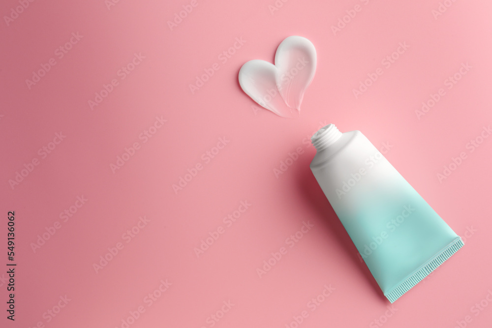 Obraz premium Tube and sample of facial cream on pink background, top view. Space for text