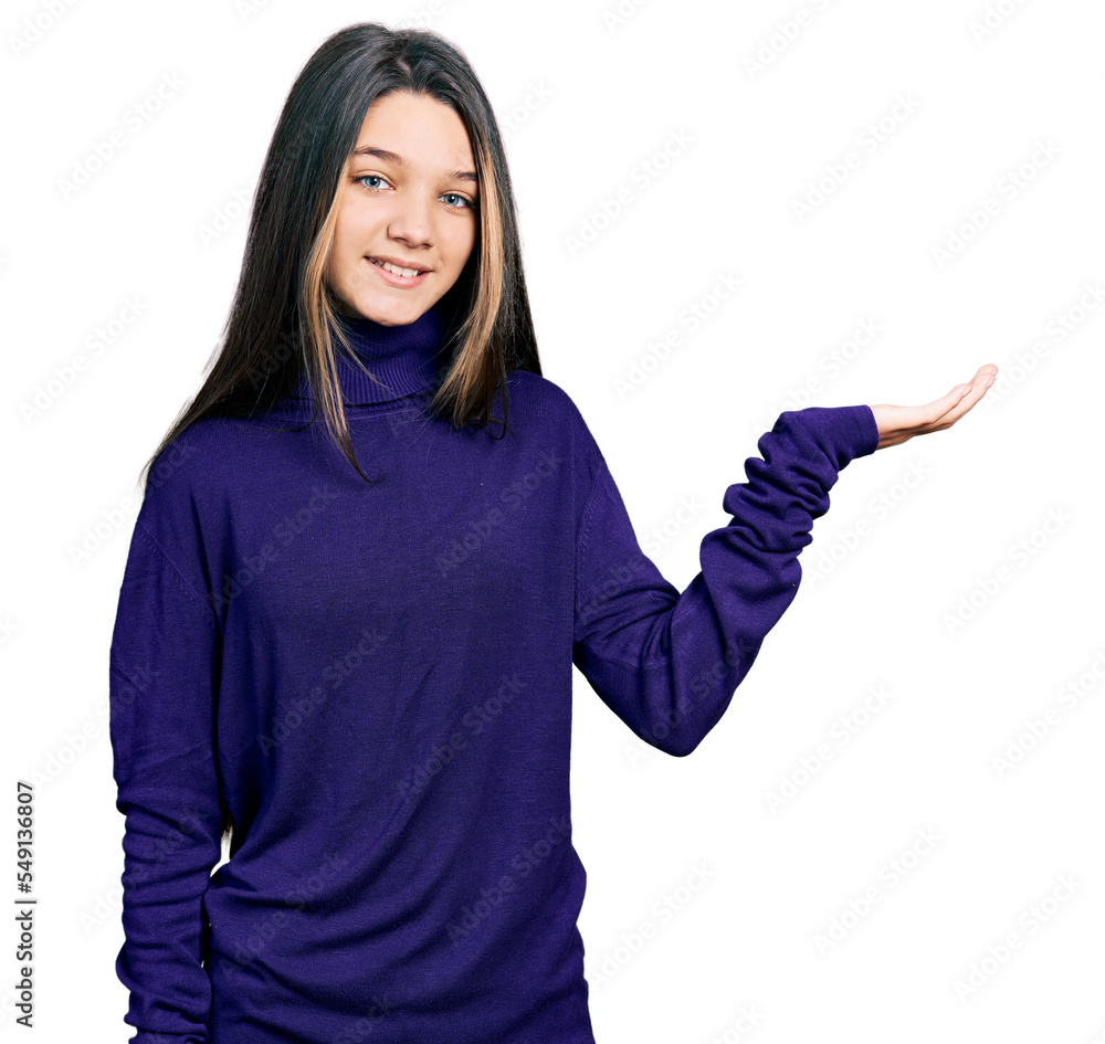 Young brunette girl with long hair wearing turtleneck sweater smiling cheerful presenting and pointing with palm of hand looking at the camera. Young brunette girl with long hair wearing turtleneck sweater smiling cheerful presenting and pointing with palm of hand looking at the camera.