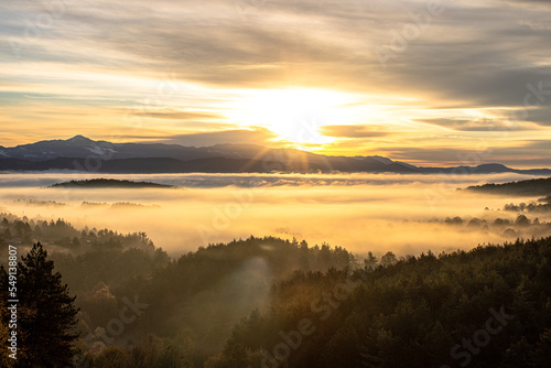 sunrise over a mountain below a misty valley 