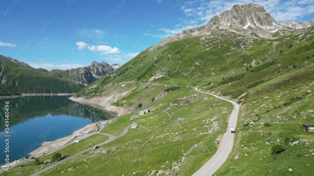 RV Motorhome drives along Mountain Lake Lac de Grand Maison in French Alps - Aerial