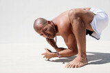 Athletic man performing acrobatic and animal like movement patterns for fitness. 
