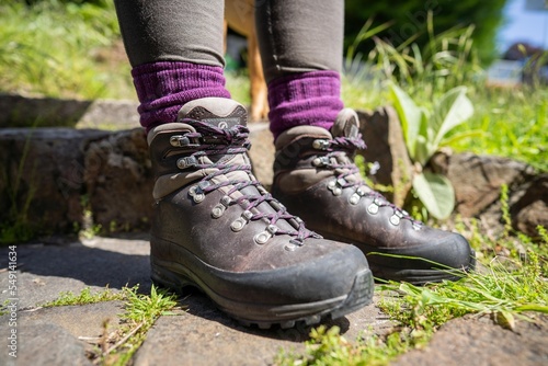 Tying shoelaces on hiking boots by a girl on a hike